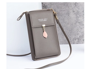 Detail of gray litchi leather phone bag with pink leaf pendant and forever lovely text
