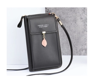 Detail of black pebbled leather crossbody bag featuring a pink leaf charm and metal zipper