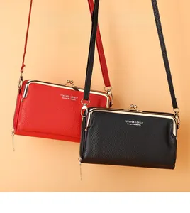 Détail de sacs bandoulière en cuir grainé rouge et noir avec cadres en métal et zip