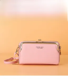 Vue de face du sac de téléphone rose en cuir grainé avec fermeture à cadre en métal doré