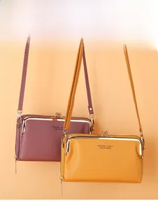 Détail des sacs de téléphone bandoulière en cuir grainé violet et jaune avec fermoirs
