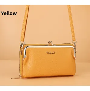 Détail de la texture en cuir litchi jaune et du fermoir à clapet doré sur le sac bandoulière
