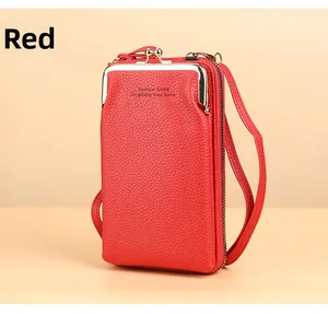 Close-up of red lychee grain leather crossbody bag with dual metal zippers and gold frame
