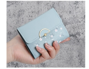 Close-up of light blue floral leather wallet with a gold semi-circle metal buckle