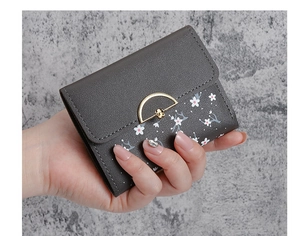 Close-up of grey floral leather wallet featuring a gold flower buckle and pebbled texture