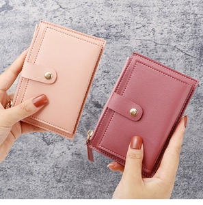 Detailed view of slim faux leather card holders in pink colors with zippers and snaps