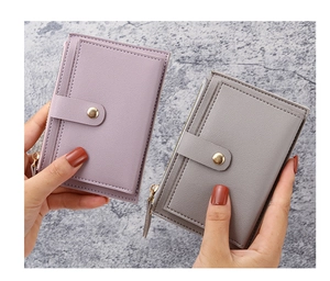 Detail of ultra-slim PU leather card holders in purple and gray with gold zipper and snap