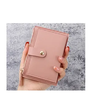 Close-up of pink litchi grain leather card holder with gold zipper and snap buckle