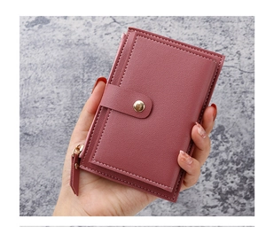 Detail of rose red leather card wallet with white stitching and metal zipper pocket