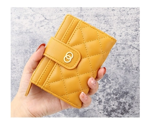 Close-up of a yellow quilted mini wallet with gold rings showing card slots and compact size