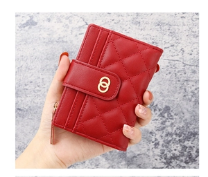 Close-up of red quilted PU leather wallet with gold metal buckle and side zipper