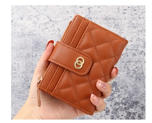 Close-up of caramel leather wallet with quilted pattern and gold metal ring buckle