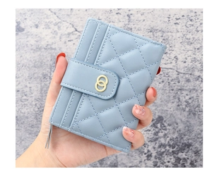 Detail of sky blue quilted leather wallet featuring gold buckles and card slots