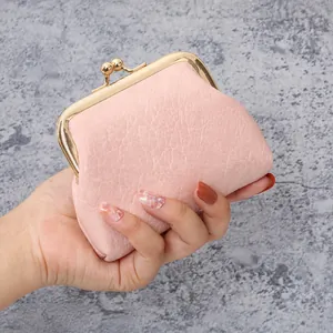 Macro detail of pink lychee textured leather mini coin purse with gold metal clasp