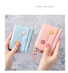 Détail de portefeuilles en cuir bleu et rose avec motif floral et fermeture éclair en métal