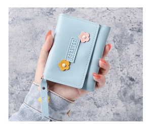 Détail d'un portefeuille bleu clair à trois volets avec fleurs 3D et gaufrage Forever