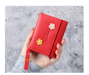 Vue détaillée du portefeuille rouge en cuir PU avec fleurs et perle sur fond texturé