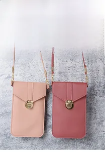 Detail view of lychee-textured PU leather phone crossbody bags with golden twist lock