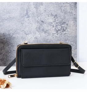 Détail du sac de téléphone en cuir noir avec poche enveloppe et fermeture éclair dorée