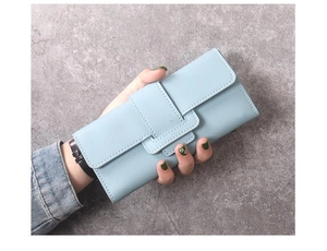 Gros plan d'un long portefeuille bleu clair en cuir PU tenu sur un fond de pierre grise