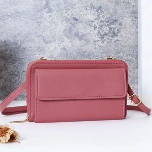 Détail du sac de téléphone rose foncé montrant le cuir grainé et la fermeture dorée
