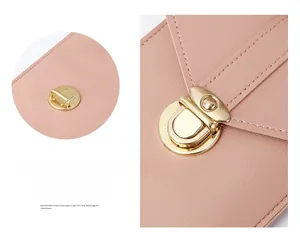 Detail of light pink pebble leather cross-body phone bag with golden rotary clasp lock