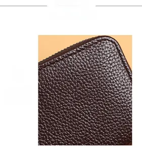 Détail de la texture cuir marron foncé avec grain lychee et coutures précises sur le bord