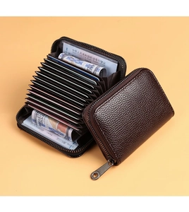 Détail d'un porte-cartes en cuir marron foncé avec fentes accordéon et fermeture éclair