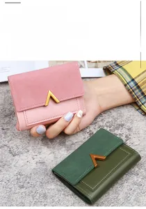 Detail of trifold faux leather wallet featuring a gold V-shape buckle and bi-material texture