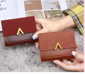 Detailed shot of tri-fold PU leather wallets with elegant V-shaped metal gold hardware