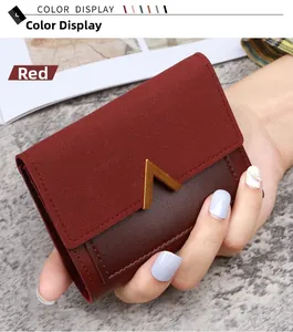 Detail view of burgundy trifold wallet with gold V-clasp and mixed leather texture