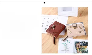 Detail of short PU leather wallet featuring hollow leaf patterns and metal leaf pendant
