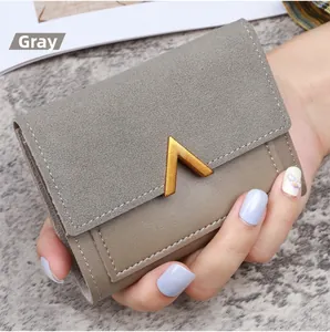 Detailed view of grey small leather wallet with golden V-shaped metal hardware detail