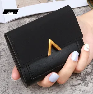 Close-up of black trifold wallet with matte and litchi texture and gold V metal buckle