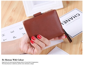 Detail of hand-held dark brown bifold wallet in litchi textured leather with zipper