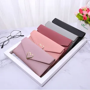 Detailed stack of faux leather envelope wallets with heart-shaped gold metal buckles