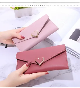 Detail of pink and burgundy long envelope wallets with heart-shaped metal buckles