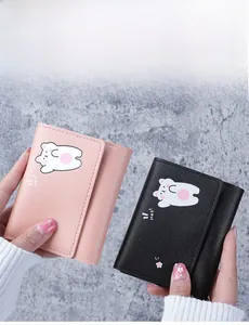Close-up of pink and black short PU leather wallets with cute cartoon bear illustration