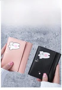 Detailed view of pink and black tri-fold PU leather mini wallets with cartoon bear design