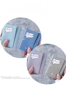Close-up of portable tri-fold mini leather wallets with cute bear illustration