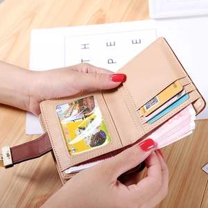 Short bifold beige and brown wallet with leaf cutout buckle and multiple card slots