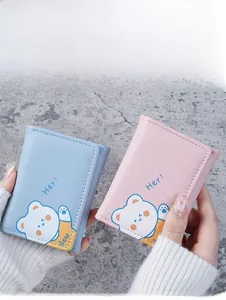 Detailed view of light blue and pink trifold wallets featuring cute bear prints and snap closure