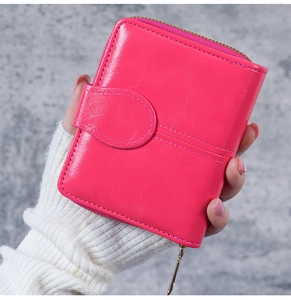 Close-up of pink oil wax leather wallet featuring a snap closure and zipper pocket