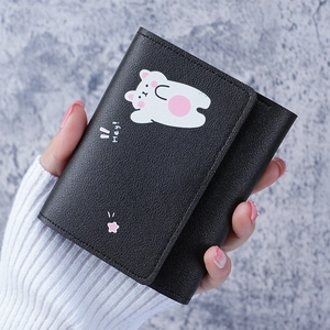 Close-up of black leather wallet featuring a white cartoon bear print and Hey! text detail