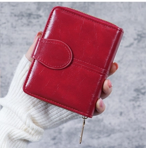 Close-up of red oil wax leather short wallet with zipper and snap button closure