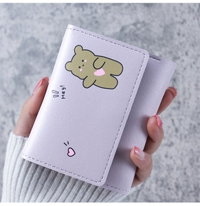 Close-up of lavender tri-fold wallet featuring cute cartoon bear and heart patterns