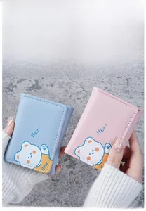 Close-up of pink and blue mini wallets with cute cartoon bears and trifold structure