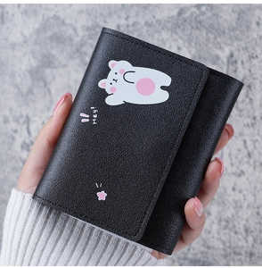 Close-up of black leather tri-fold wallet with cute cartoon bear print and Hey text