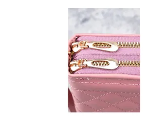 Détail des doubles fermetures éclair dorées et cuir matelassé rose du portefeuille