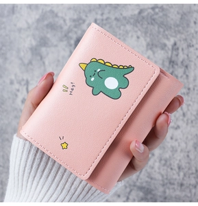Close-up of pink three-fold wallet with cute green dinosaur print and star details